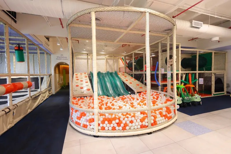 Área de juegos con alberca de pelotas, resbaladillas, túneles y carritos