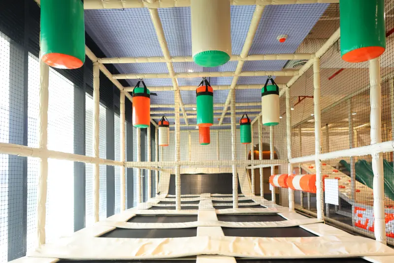 Trampolines con colchonetas, dentro de una red de protección